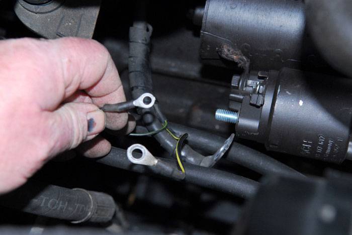 Câbles branchés sur un démarreur dans le compartiment moteur